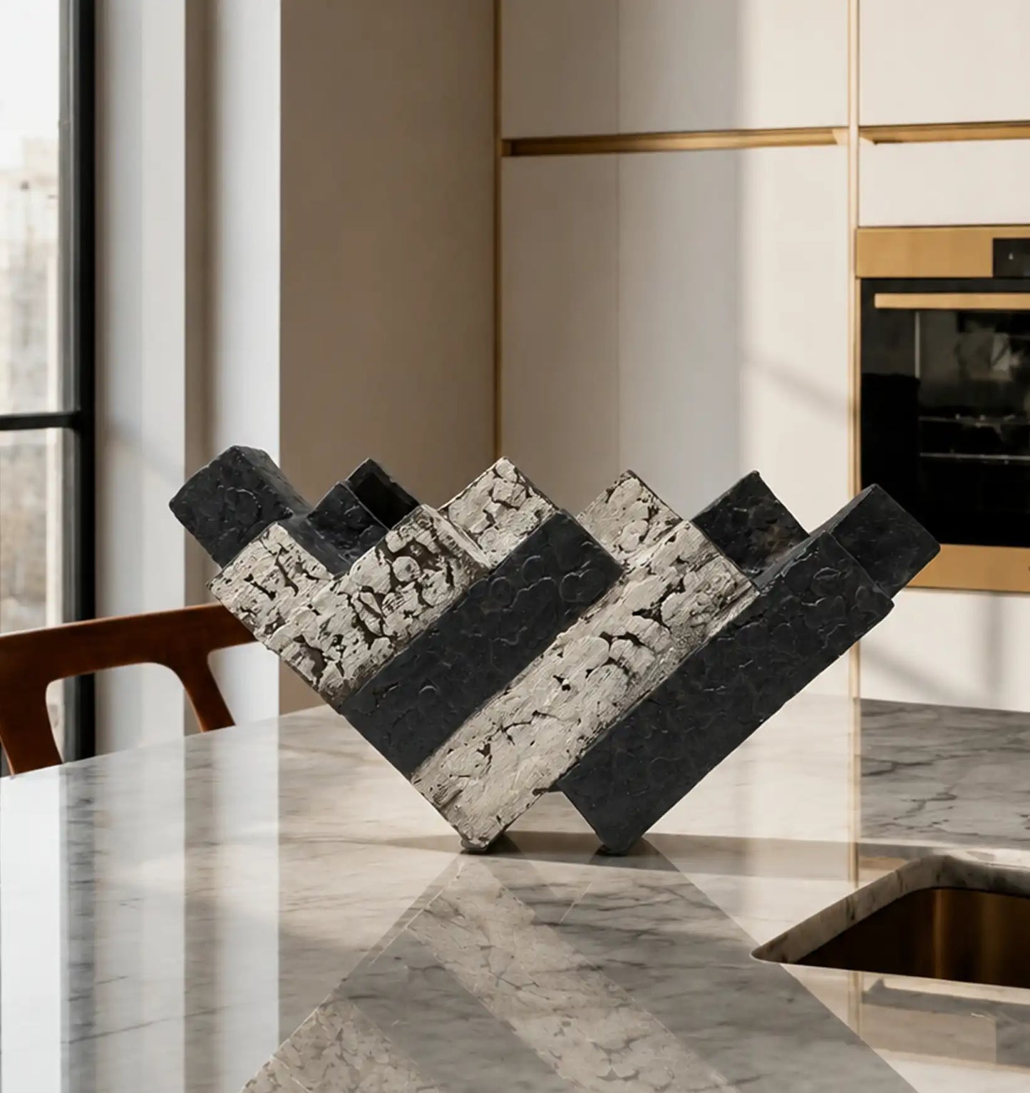 Black and white textured decorative object on a marble kitchen island