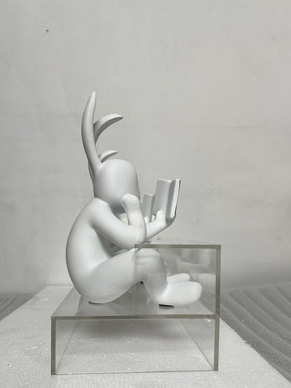 White abstract sculpture on a clear glass platform against a gray background