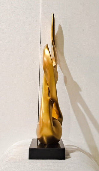 Gold abstract sculpture on a white background