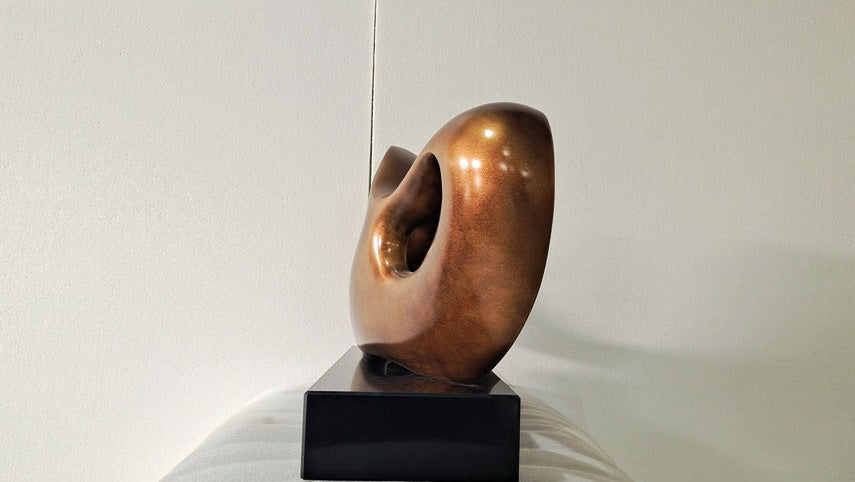 Bronze sculpture on a black base against a white background