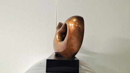 Bronze sculpture on a black base against a white background