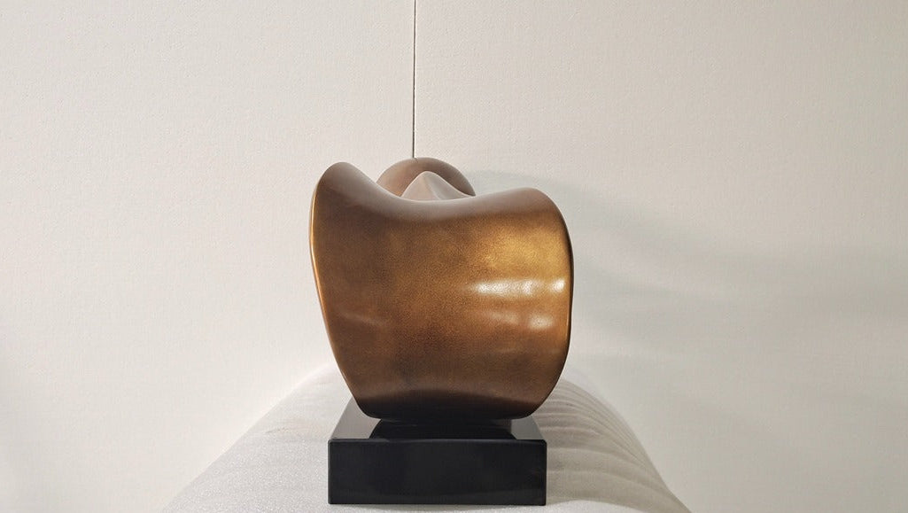 Bronze sculpture on a white pedestal against a plain background