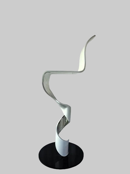 Modern floor lamp with a black base and white spiral design on a textured surface.