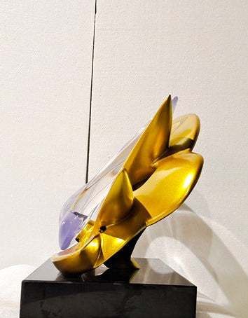 Decorative sculpture with gold and black design on a white surface