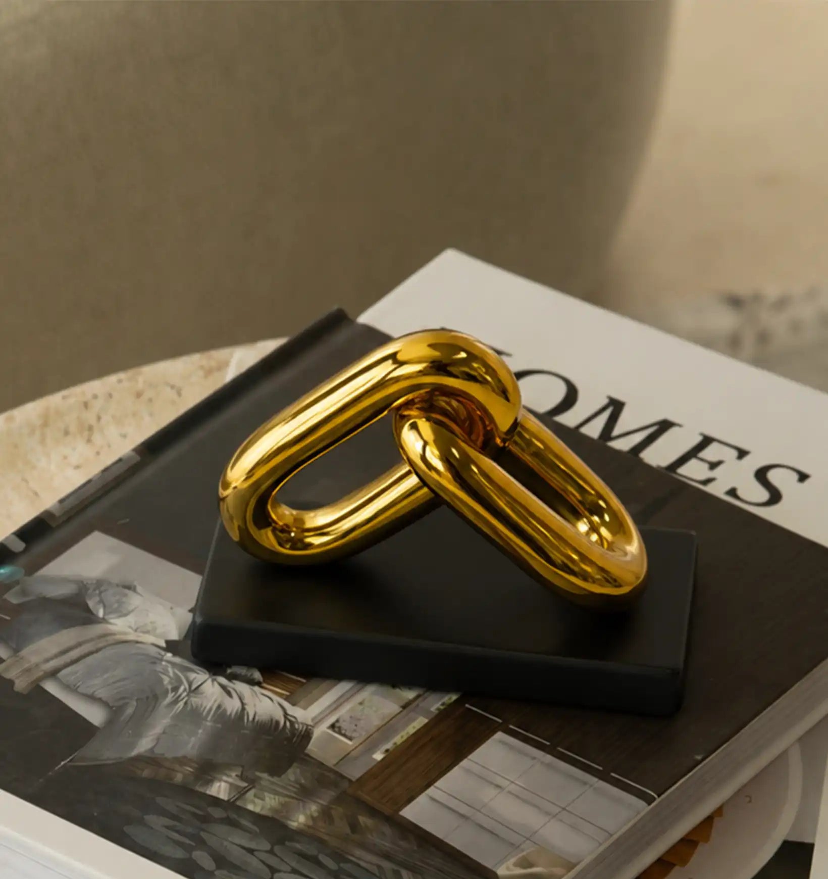 Two interlocking gold chain links on a black book with white pages