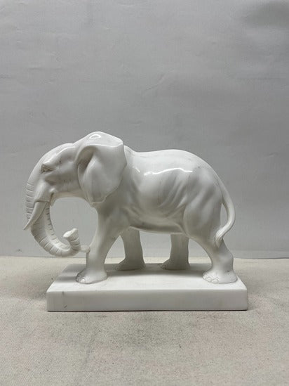 White ceramic elephant statue on a light gray background