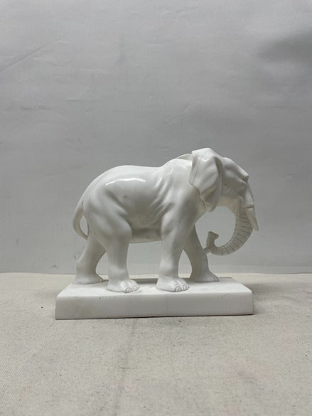 White marble elephant sculpture on a plain background