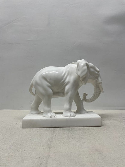 White marble elephant sculpture on a plain background